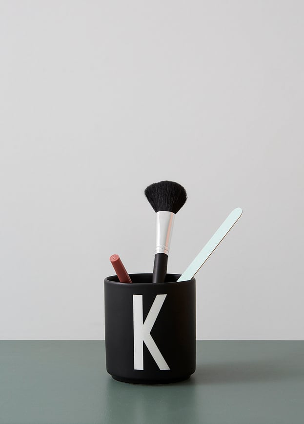 Taza de porcelana AJ, negra, con letra L