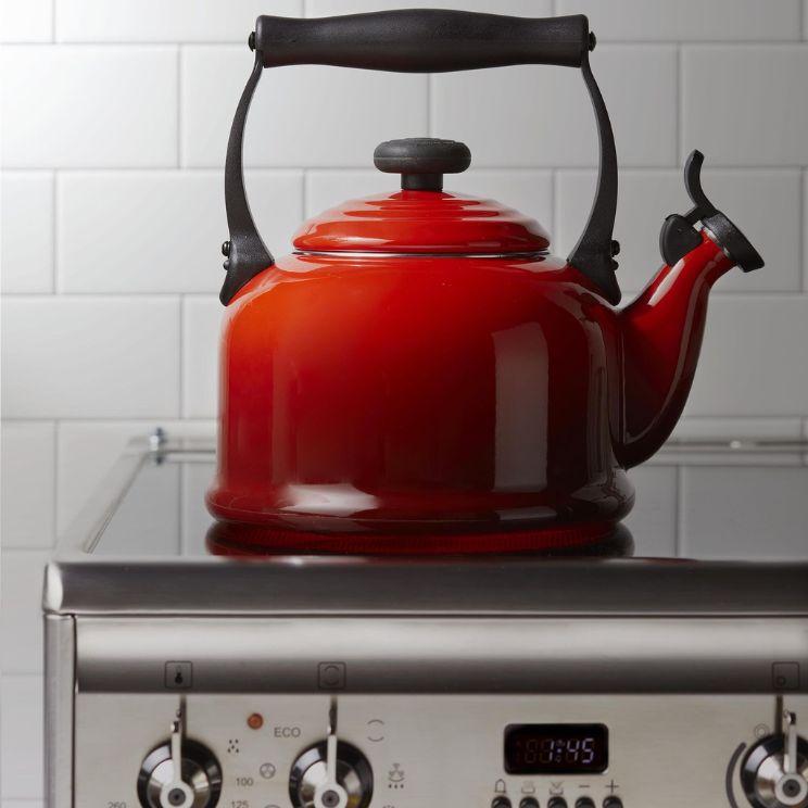 rdeč čajnik Le Creuset na kuhalni plošči