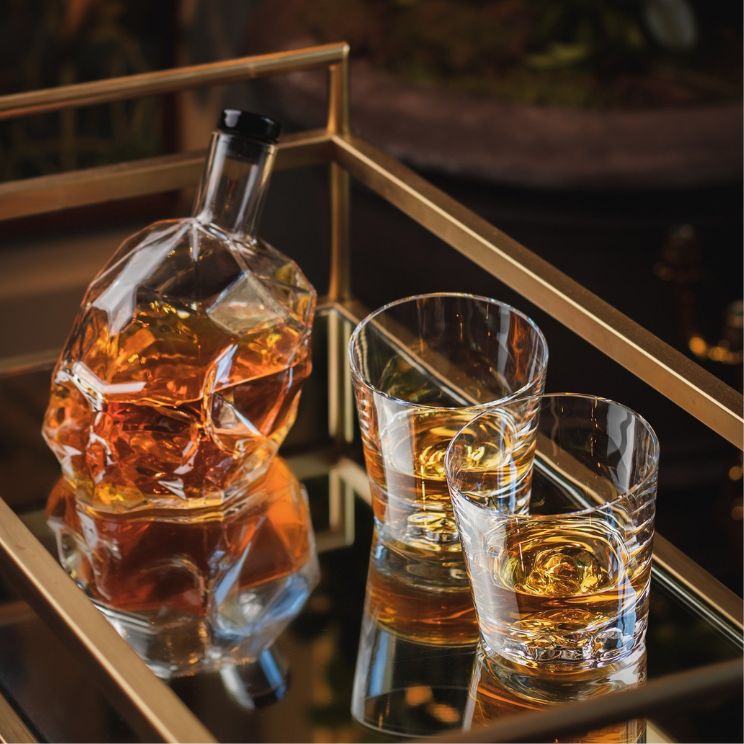 zestaw szklanek do whisky na tacy, obok karafka w kształcie czaszki
