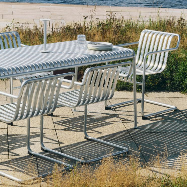 Langer weißer Palissade-Tisch mit Stühlen am Meer
