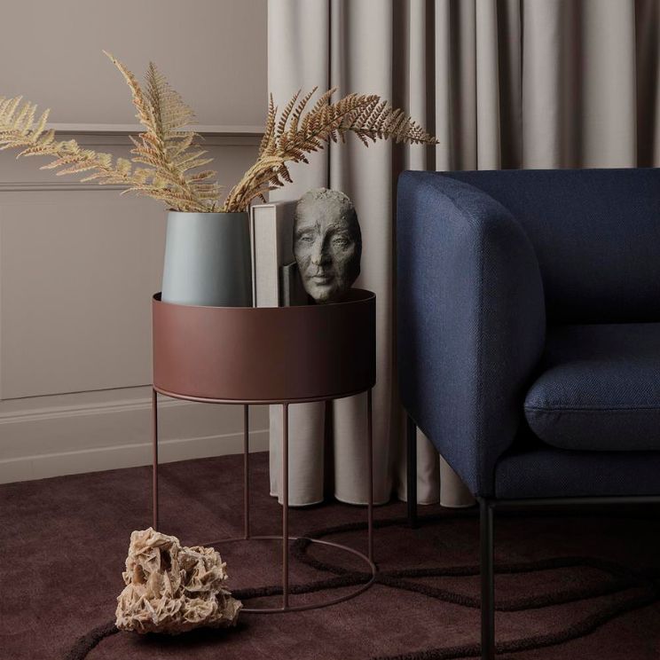 Jardinière ronde Ferm Living à côté d'un fauteuil