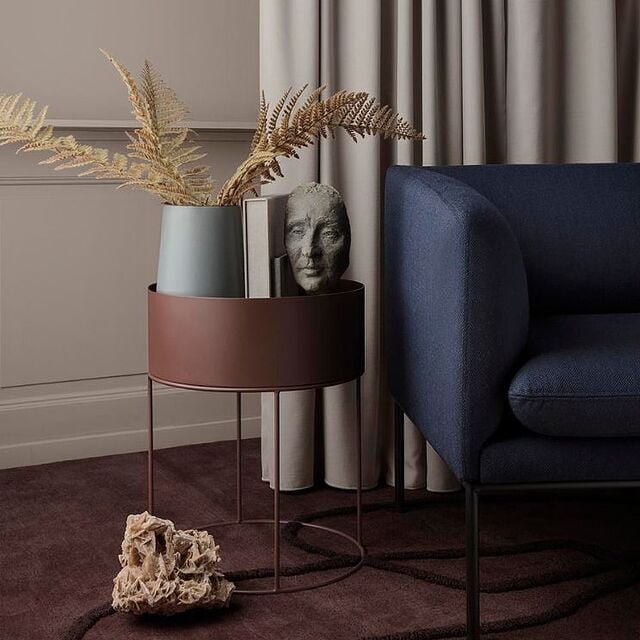 Jardinière ronde Ferm Living à côté d'un fauteuil