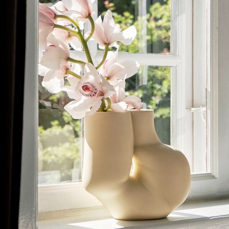 Vase en porcelaine Chubby jaune clair avec des fleurs sur le rebord de la fenêtre